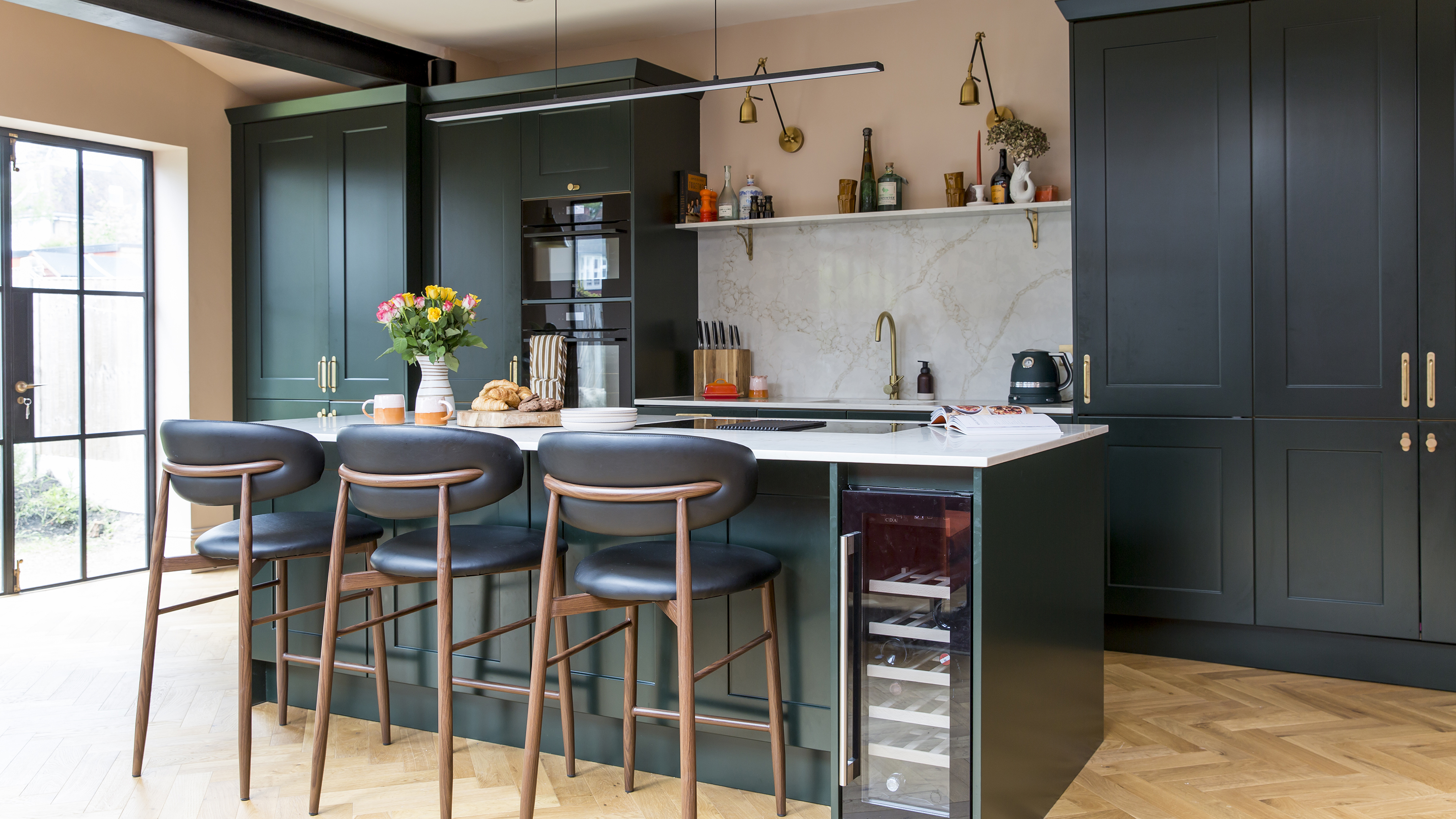 Green kitchen with island and pink walls