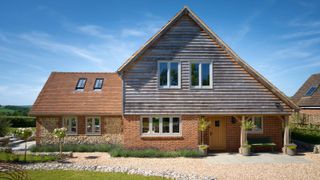 large brick and stone house with oak frame extension and cladding to front of property