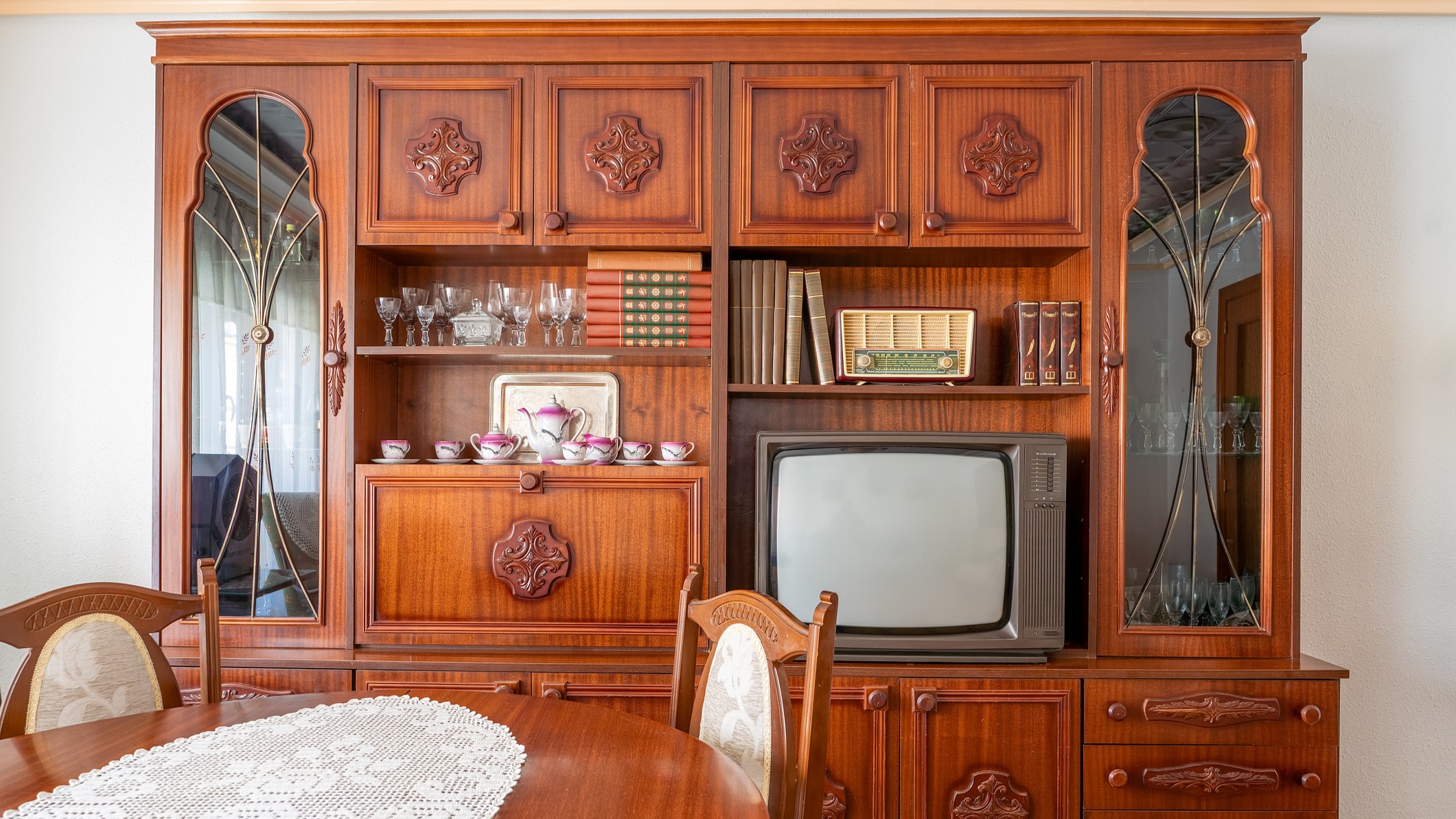 Old fashioned living room with wooden furniture and vintage television showing decorating trends from the 1980s.