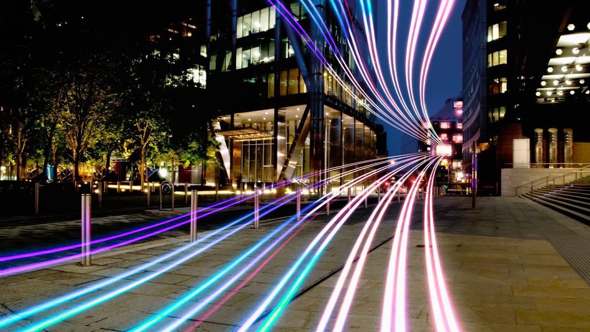 Internet connection concept image showing flashing data flows through a street at night.