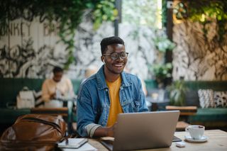 A student working in a cafe while enjoying a coffee.