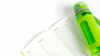 a photo of a workout diary and water bottle