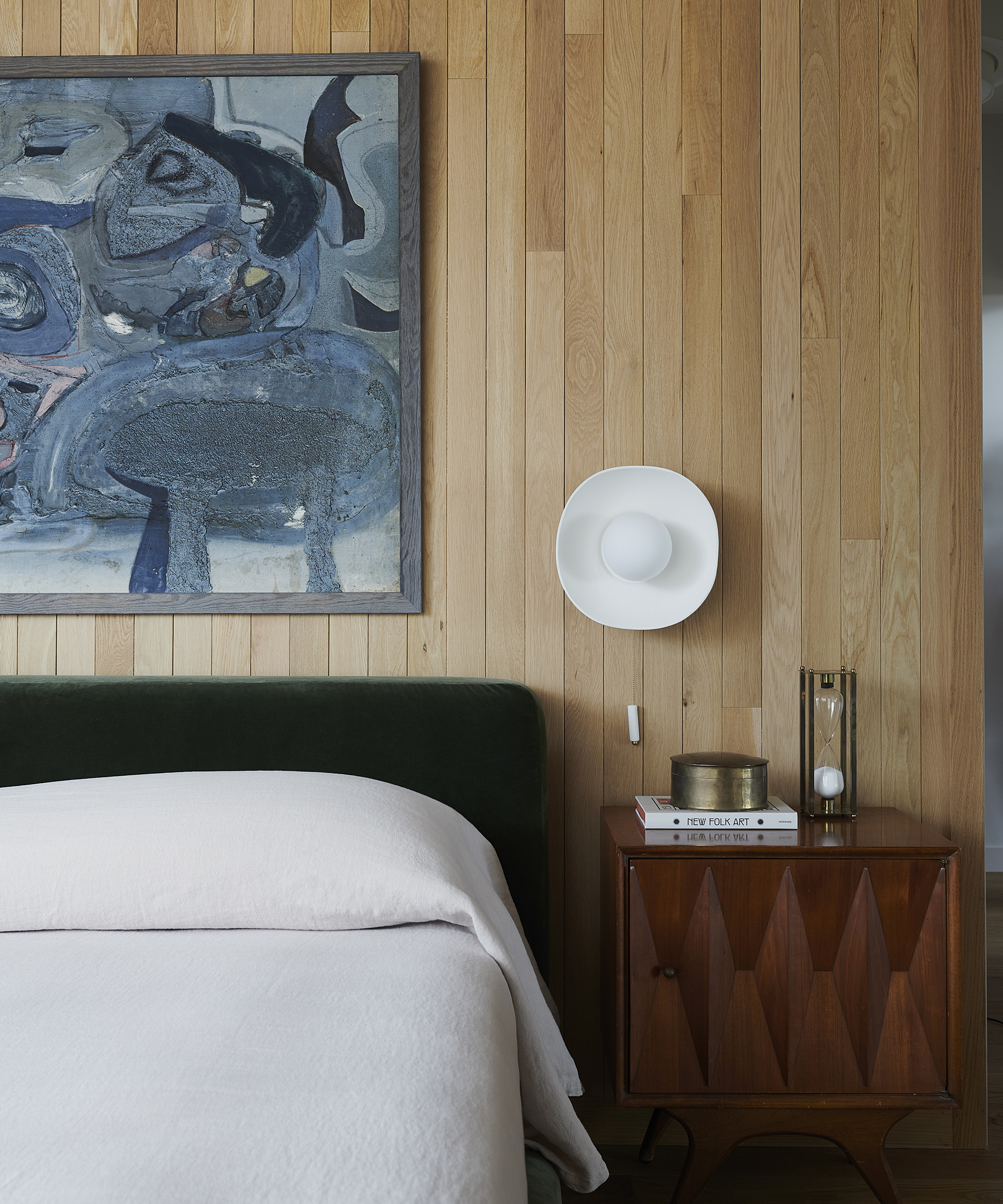 bedroom with wood walls and round white wall light