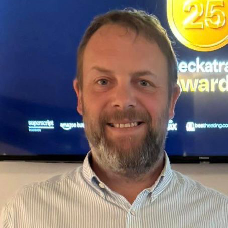 male with short hair and beard wearing striped shirt