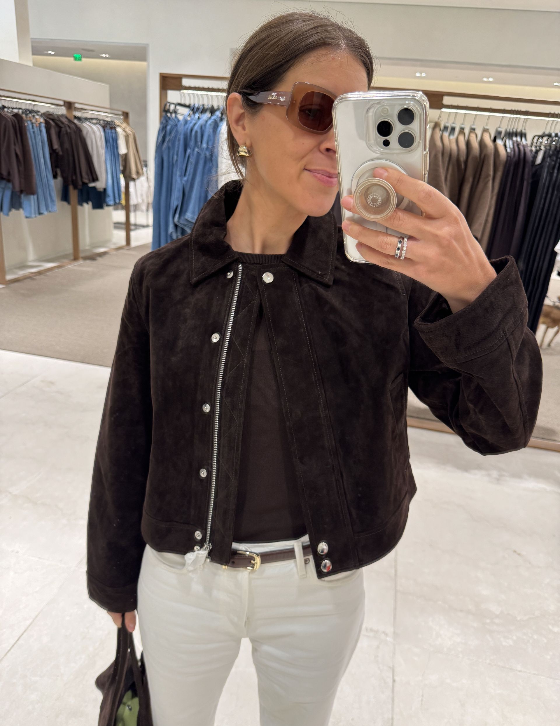 Woman in dark brown suede jacket and white jeans