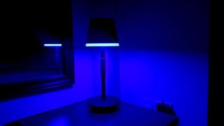 Philips Hue Go portable table lamp on a bedside table