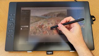 Ugee 16 review; photos of a person painting using a drawing tablet display