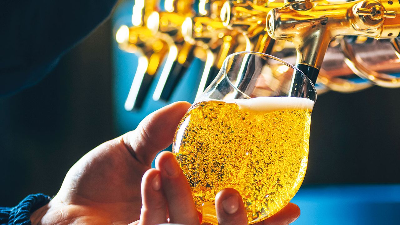 Barman pouring beer in glass