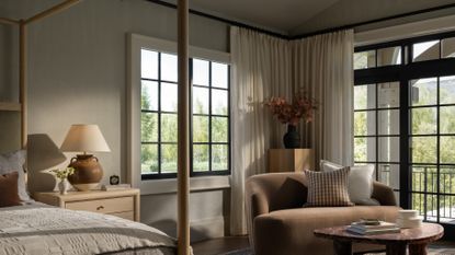 A bedroom with earthy tones and a corner with dry flower arrangement