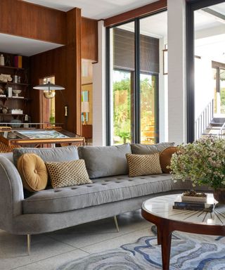 Grey sofa, blue rug, wooden shelves