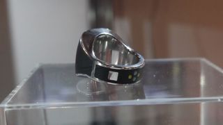 The silver button sits on the back left of the ring