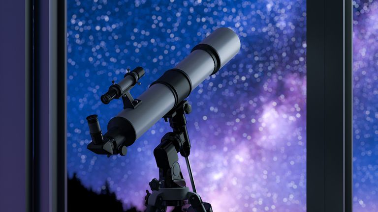 best telescope for stargazing 2022: telescope pointed out of a window at the stars