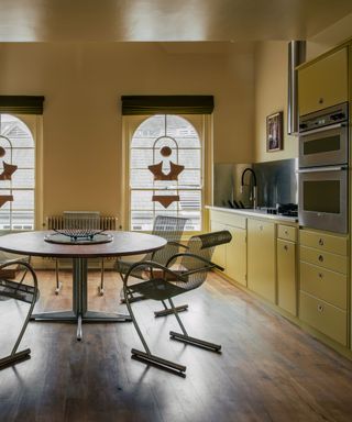 yellow kitchen with glossy ceiling and stain glass windows with chrome accessories