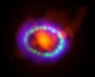 Composite image of supernova 1987A. ALMA data (in red) shows newly formed dust in the center of the remnant. HST (in green) and Chandra (in blue) show the expanding shockwave.