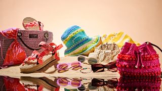 An image of the coolest summer accessories to see you through the season including vibrant bright raffia bags, sandals, bucket hats, sunglasses and jewellery