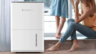 TaoTronics dehumidifier on floor beside mother and child