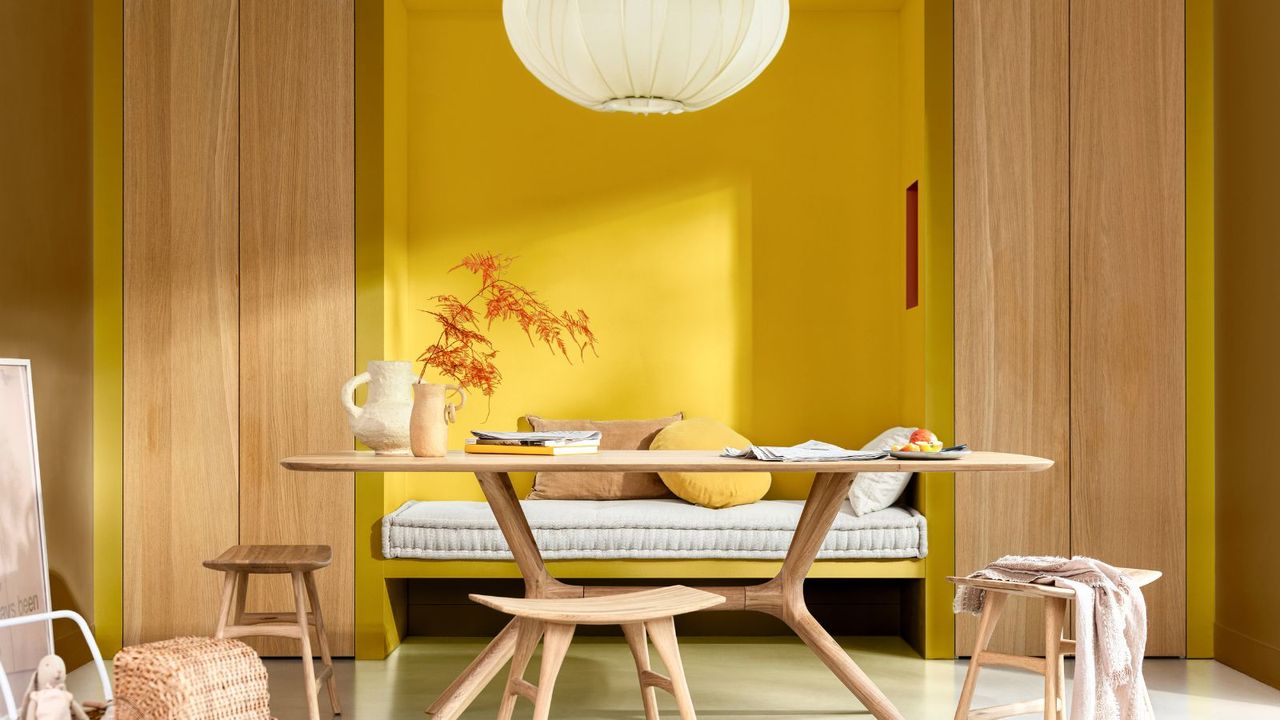 bright yellow home office with light wooden furniture 