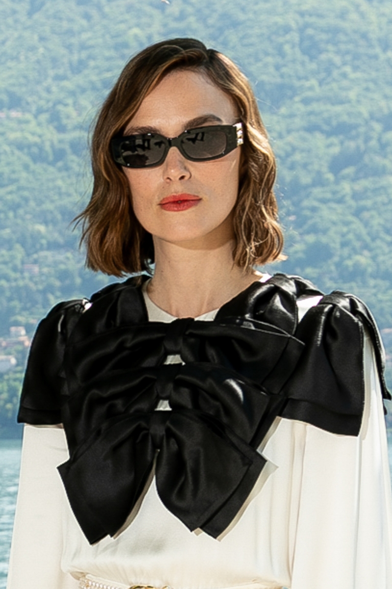 Keira Knightley is pictured with a wavy bob hairstyle and wearing a black and white dress at the Chanel Cruise 2026 show held at the Villa d'Este on April 29, 2025 in Lake Como, Italy.