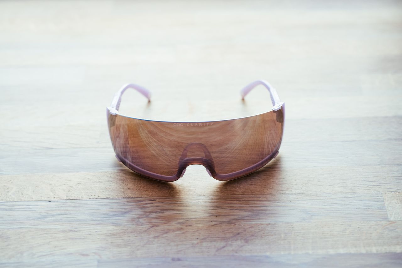 A space-age looking pair of wraparound cycling glasses on a wooden surface