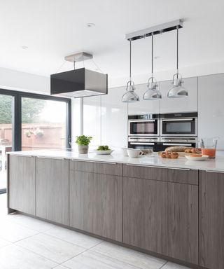 A narrow kitchen area in an open plan space with a kitchen island