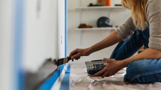 A woman painting a wall