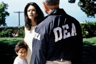 Catherine Zeta-Jones as Helena Ayala, being held back by DEA agents in Traffic