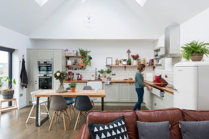 A double-height kitchen diner extension with rooflights, built-in kitchen units and a family dining table