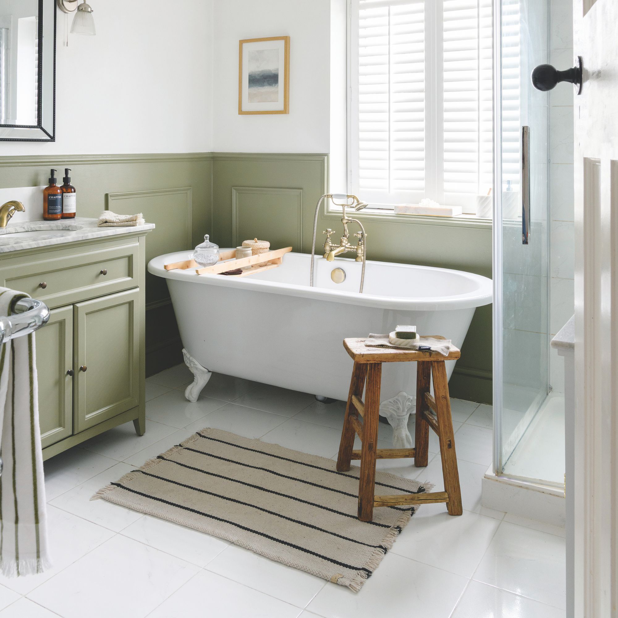 Bathroom with green panelling on the walls, white floor tiles, and a freestanding bathtub