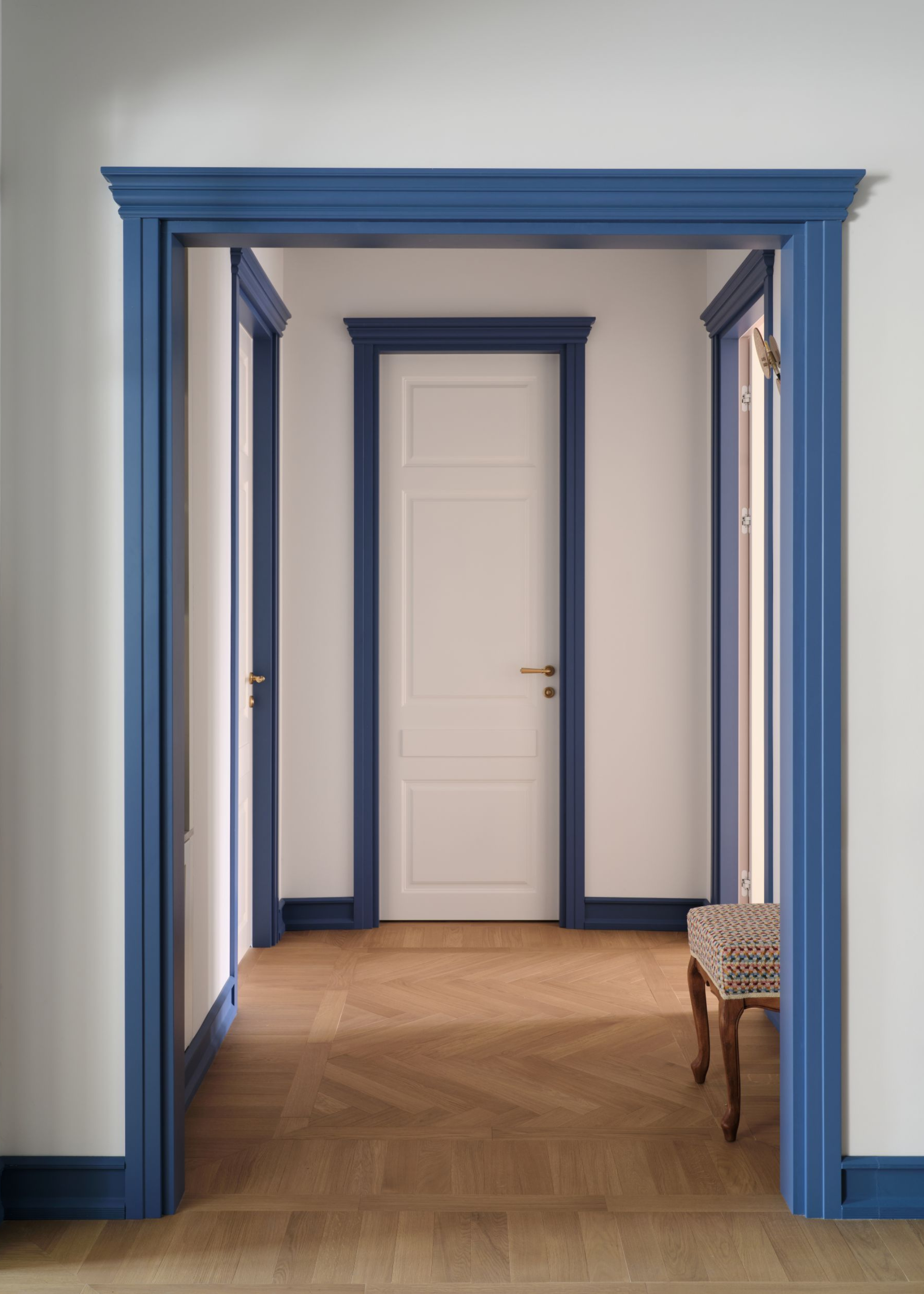 Open hallway with three doors all with a blue trim