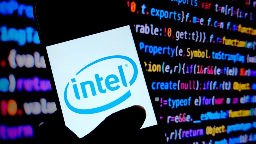 The Intel logo displayed on a smartphone in front of a screen of computer code