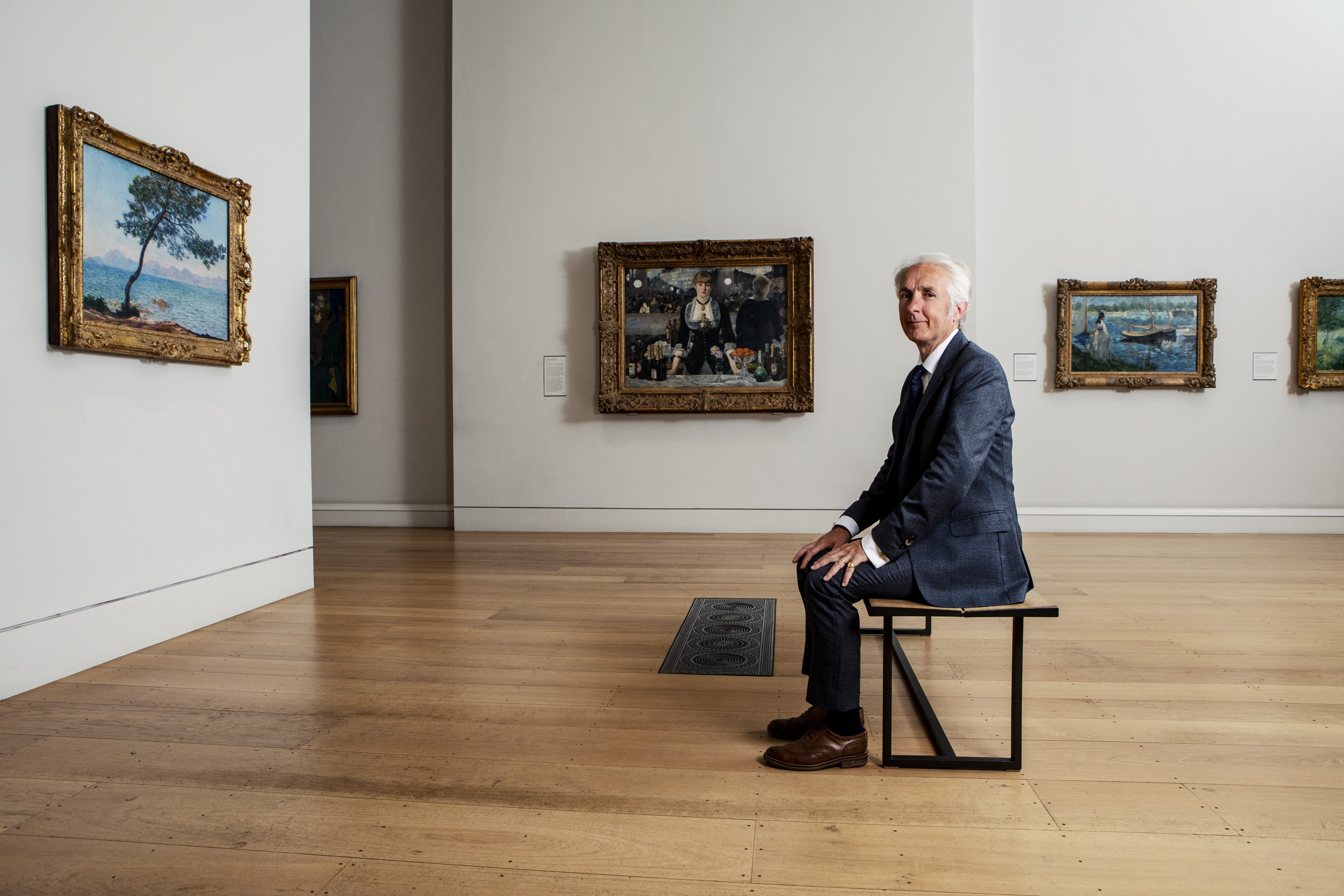 A portrait of Ernst Vegelin van Claerbergen, surrounded by paintings in the Courtauld Gallery
