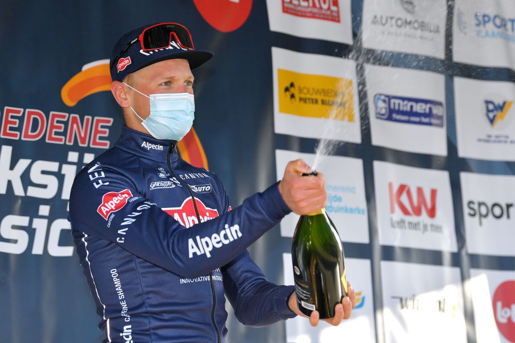 KOKSIJDE BELGIUM MARCH 19 Podium Tim Merlier of Belgium and Team AlpecinFenix Celebration during the 19th Bredene Koksijde Classic 2021 a 199km race from Bredene to Koksijde Mask Covid safety measures Flowers BredeneKoksijde on March 19 2021 in Koksijde Belgium Photo by Luc ClaessenGetty Images