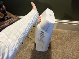 A woman holding a small dehumidifier in one hand