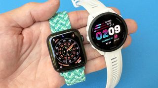 Close-up of the Apple Watch SE 3 next to the Garmin Forerunner 70