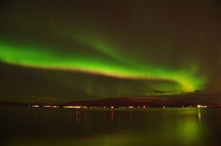 Intense northern lights on the Reykjavik coast, Iceland.