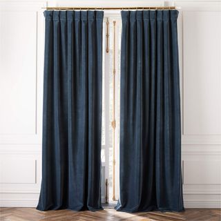 Dark teal curtains hanging on a white wall