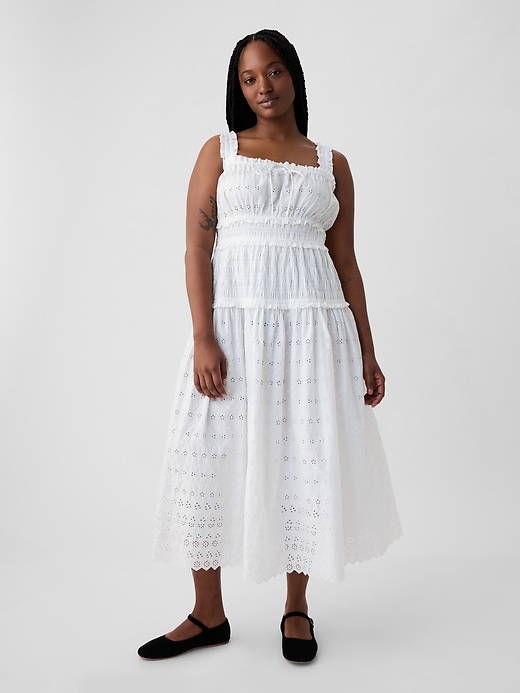 a model wears a white sleeveless dress with shirred and eyelet details 