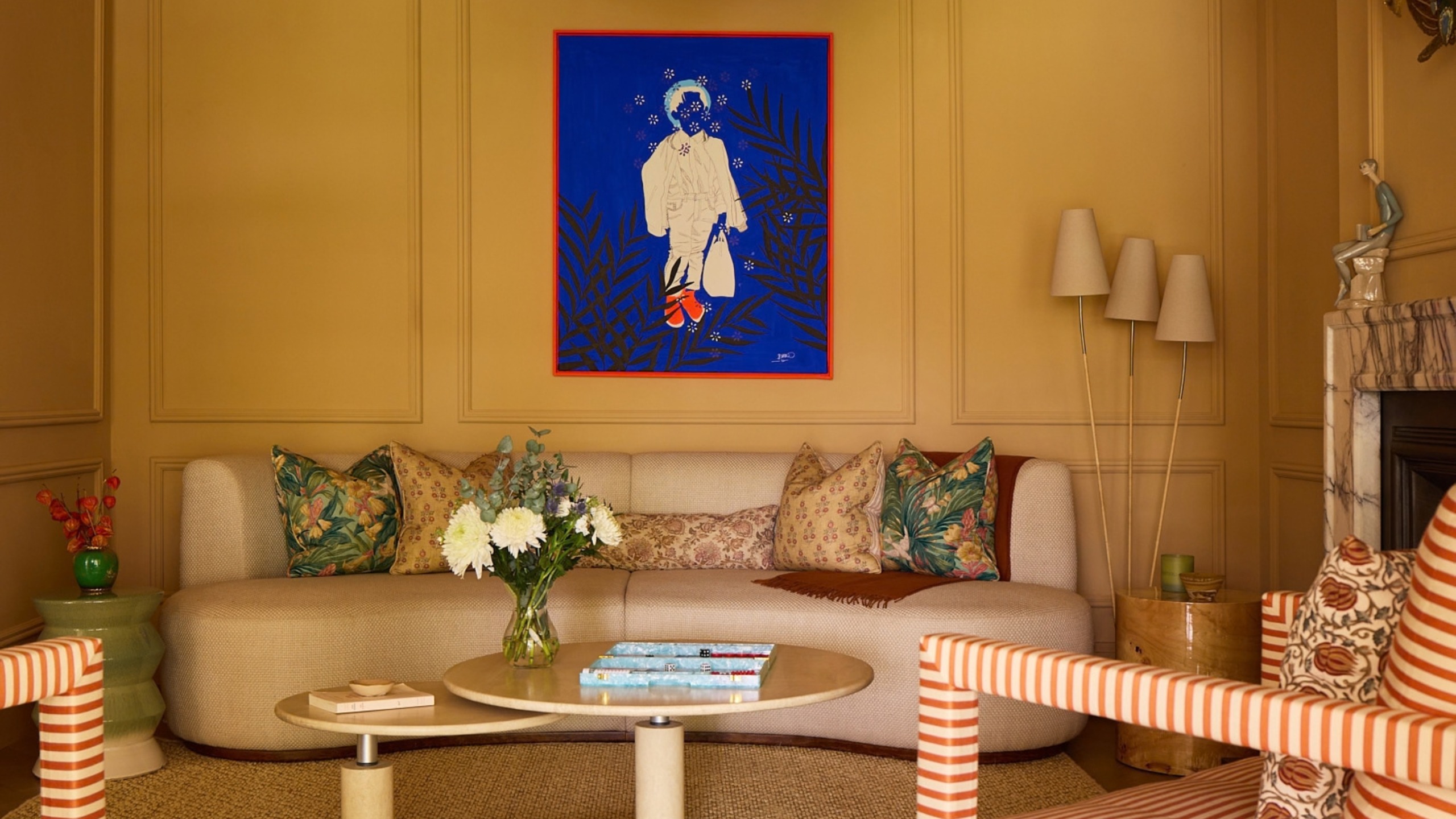 a yellow living room with neutral furniture and a bright red and blue wall art