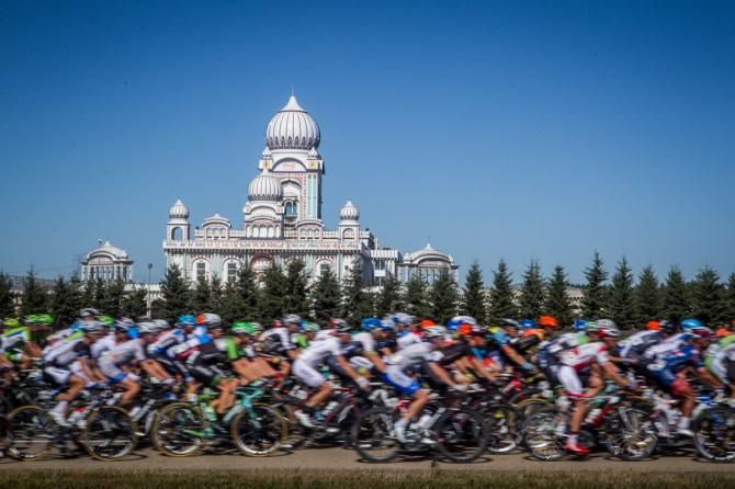The field passes by a Mosque along today's course