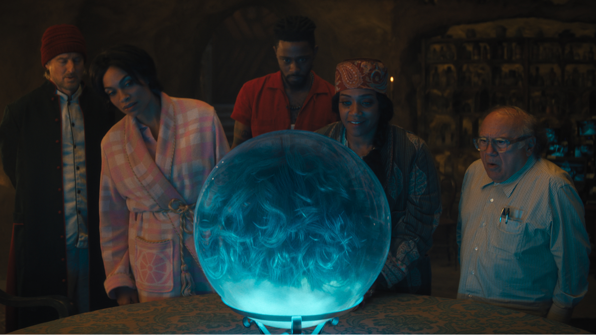 Gabbie, Ben, and Harriet standing around Madame Leota&#039;s crystal ball in Haunted Mansion