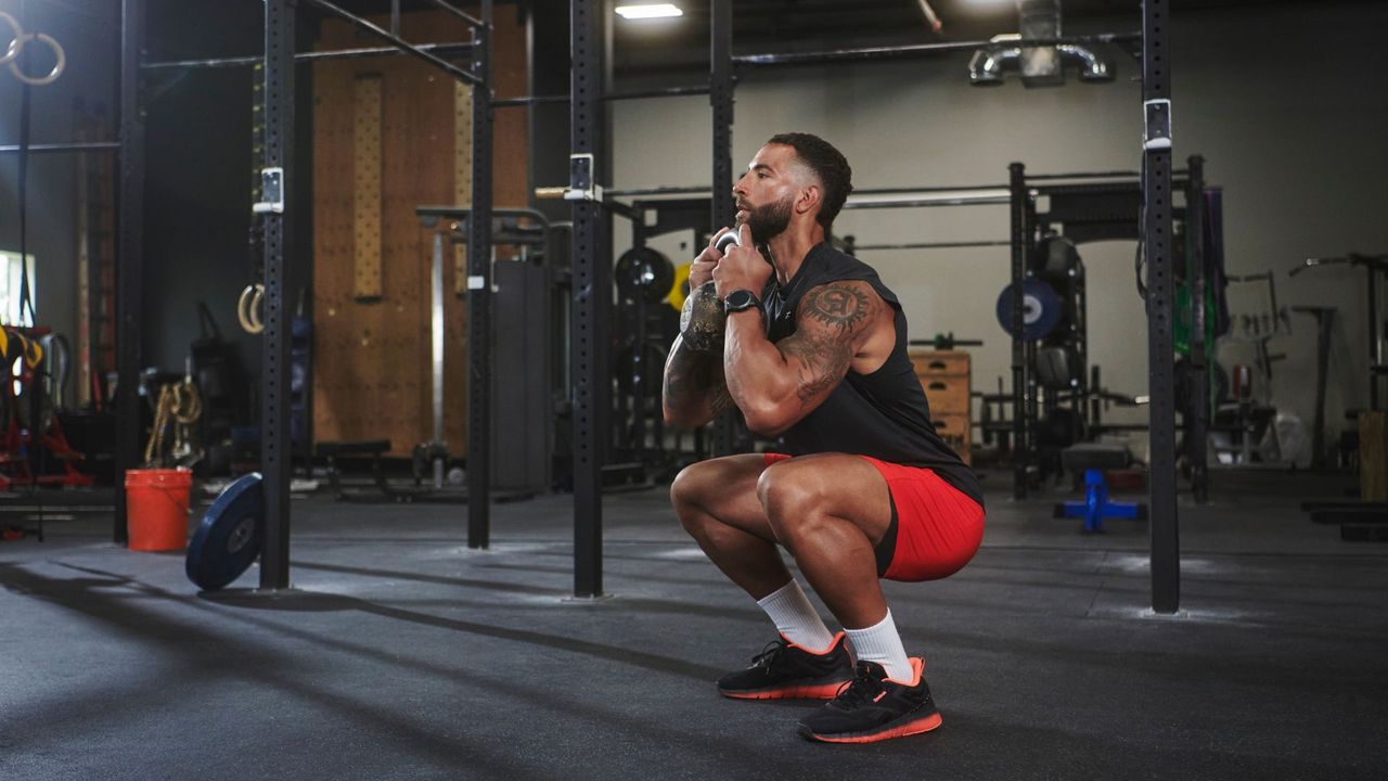 A man in a crossfit box wearing the Reebok Nano Gym Training shoe doing goblet squats