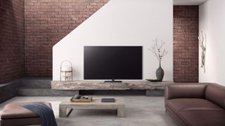 The Panasonic HX940 LED TV in a living room with white and brick walls