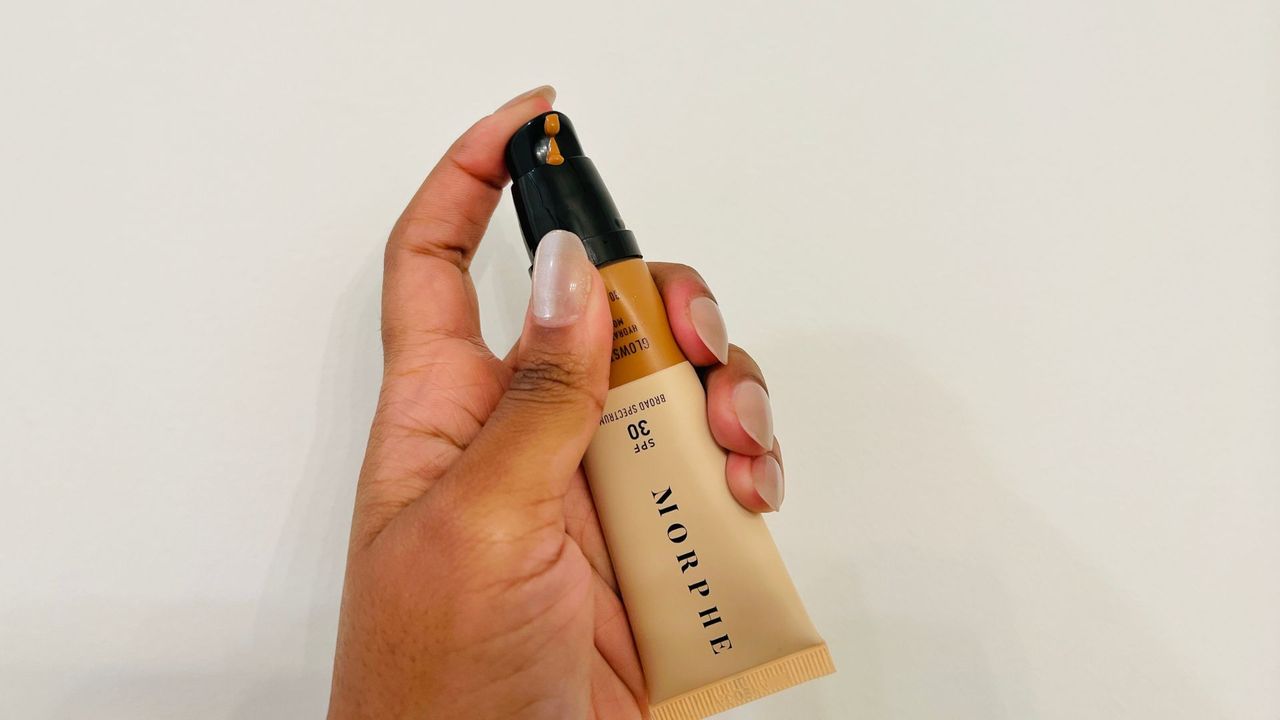 A person holding an opened Morphe Glowstunner Hydrating Tinted Moisturizer SPF 30 for the best foundations with SPF.