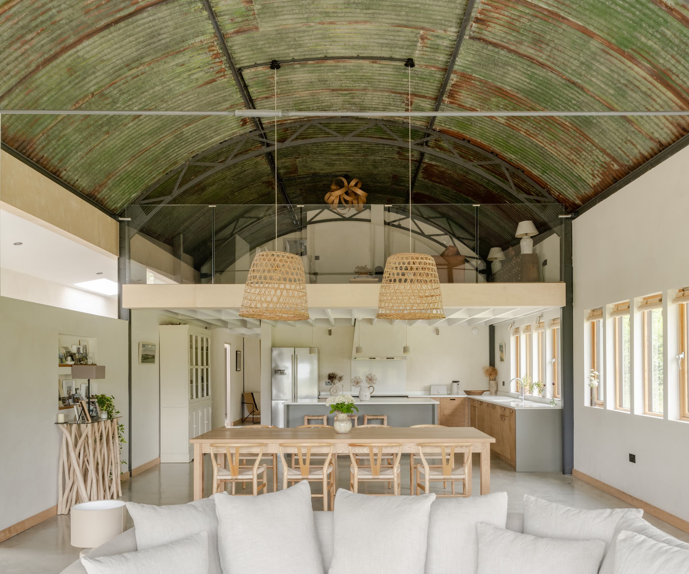 A living area with a mezzanine level above and a Corten steel roof