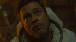 Brad Pitt, wearing a space suit, stares up to see his father in Ad Astra