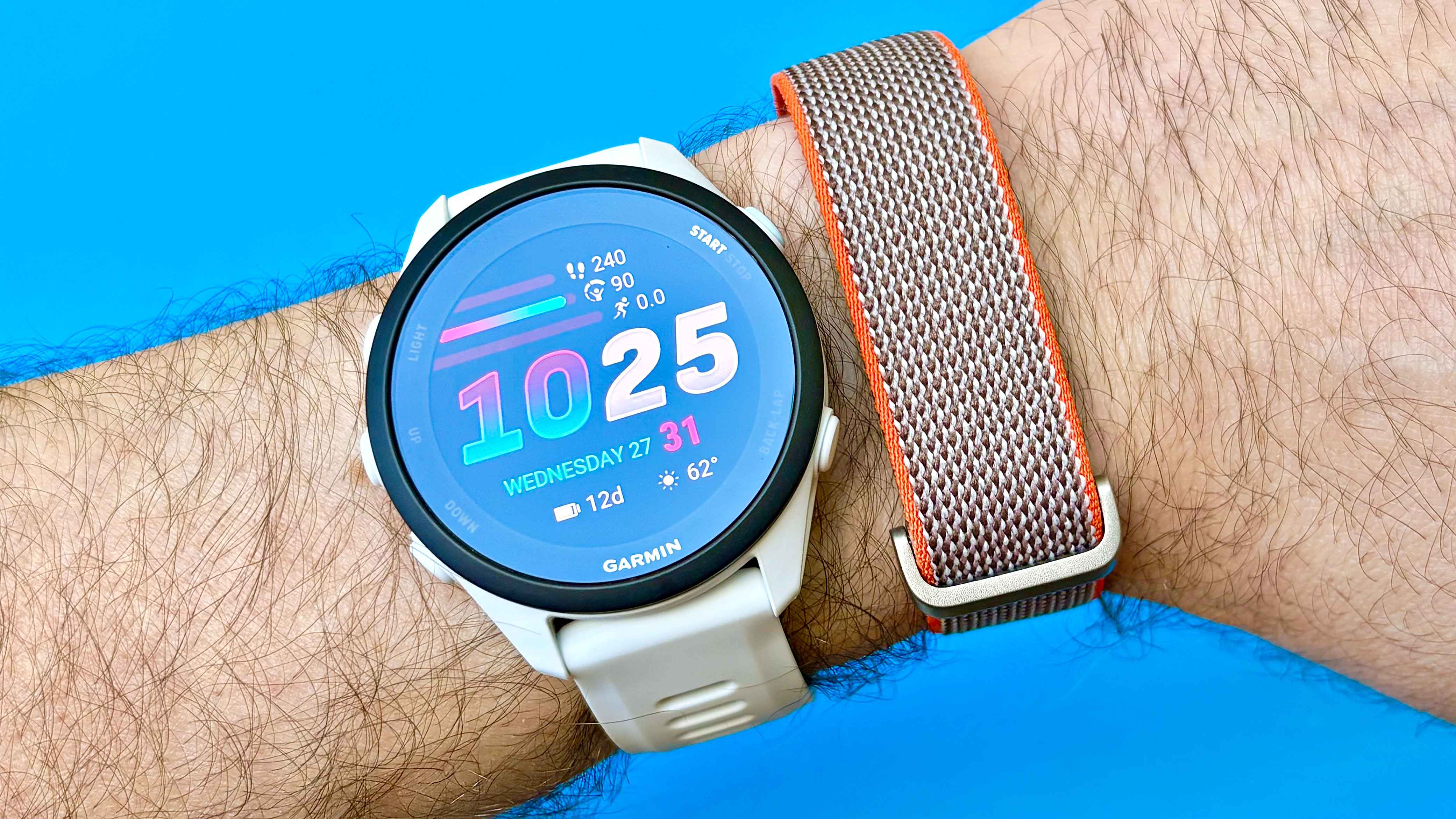 Close-up of the Garmin Forerunner 70 next to the Fitbit Air fitness tracker on the same wrist