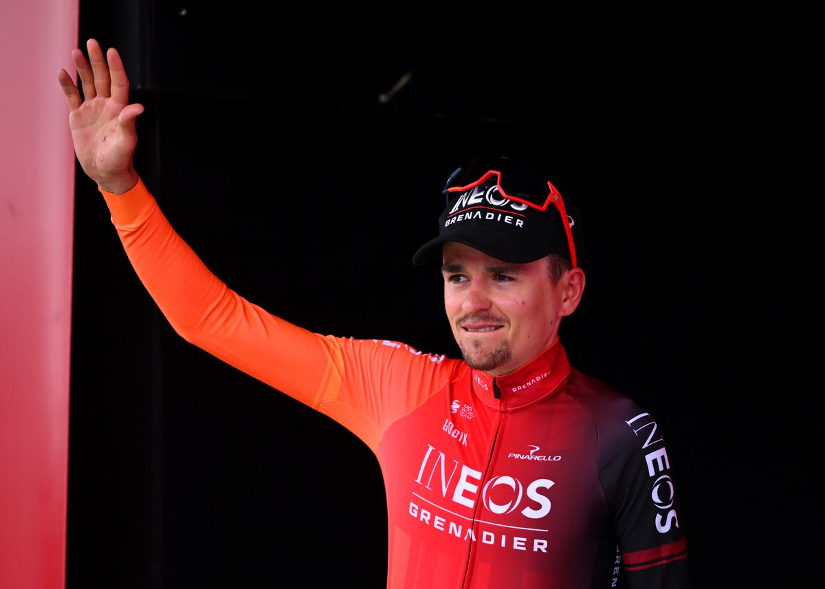 Tom Pidcock waves on the podium after winning the Amstel Gold Race 