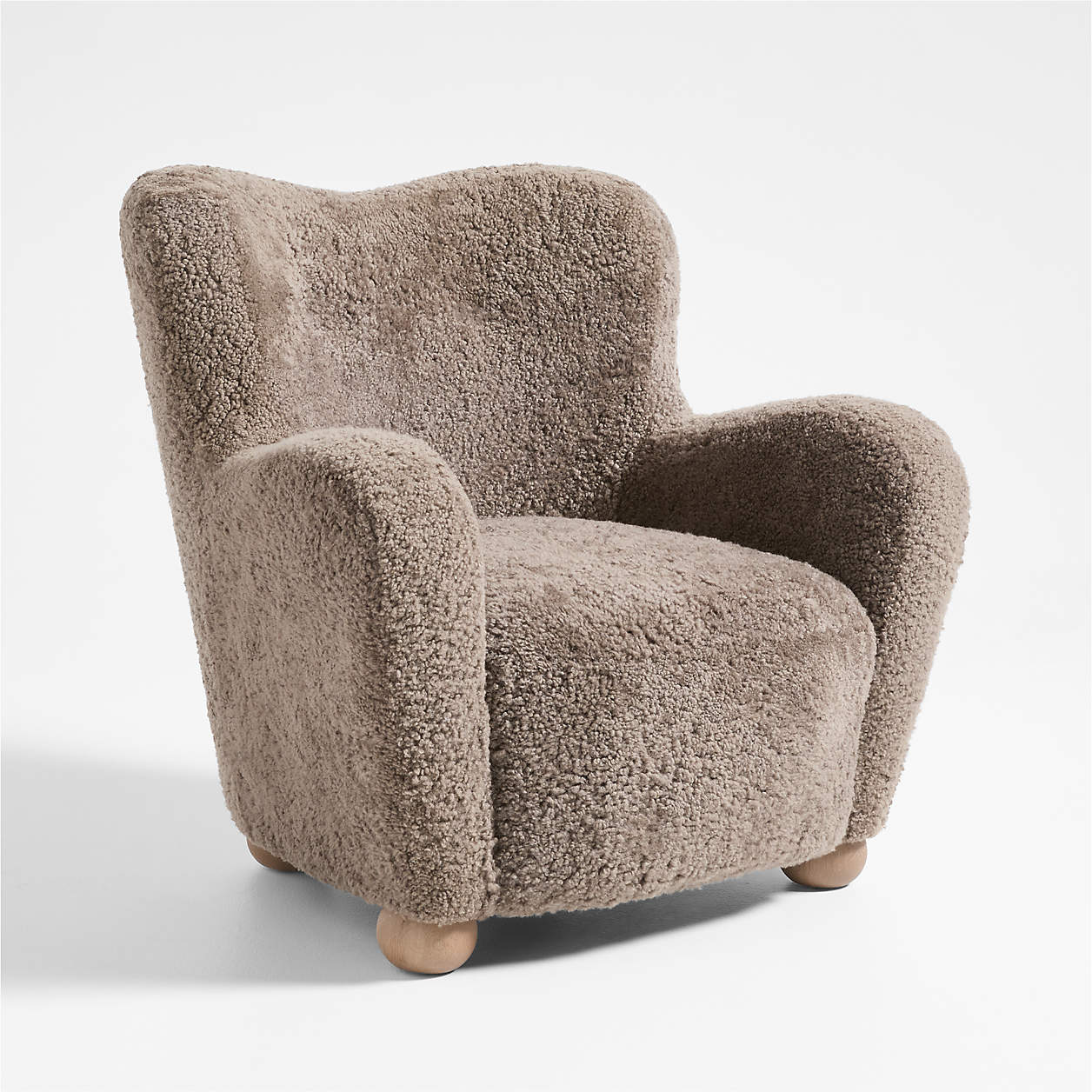 Shearling upholstery covers this curvy club chair with bun-shaped feet. 