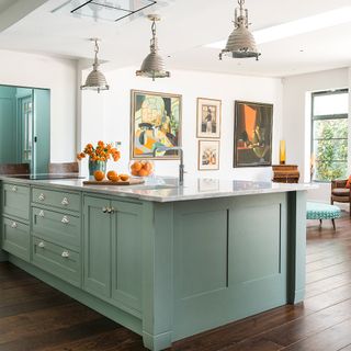 kitchen room with teal colour kitchen counter and marble work top on it and wooden flooring