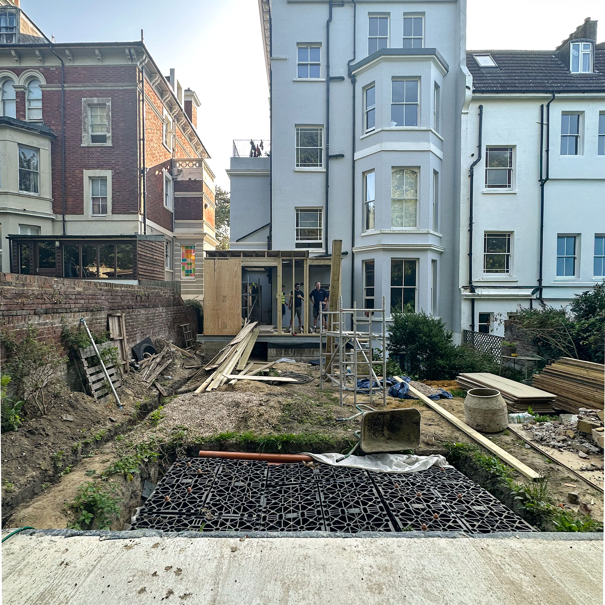 Exterior rear of house with garden, extension and summerhouse mid-renovation and building works